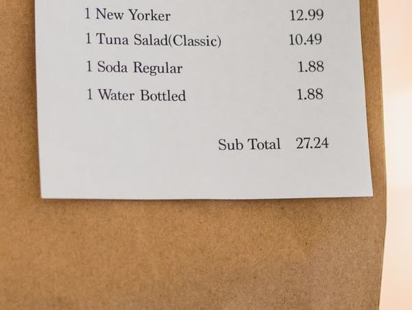 A paper receipt being photographed by a phone camera